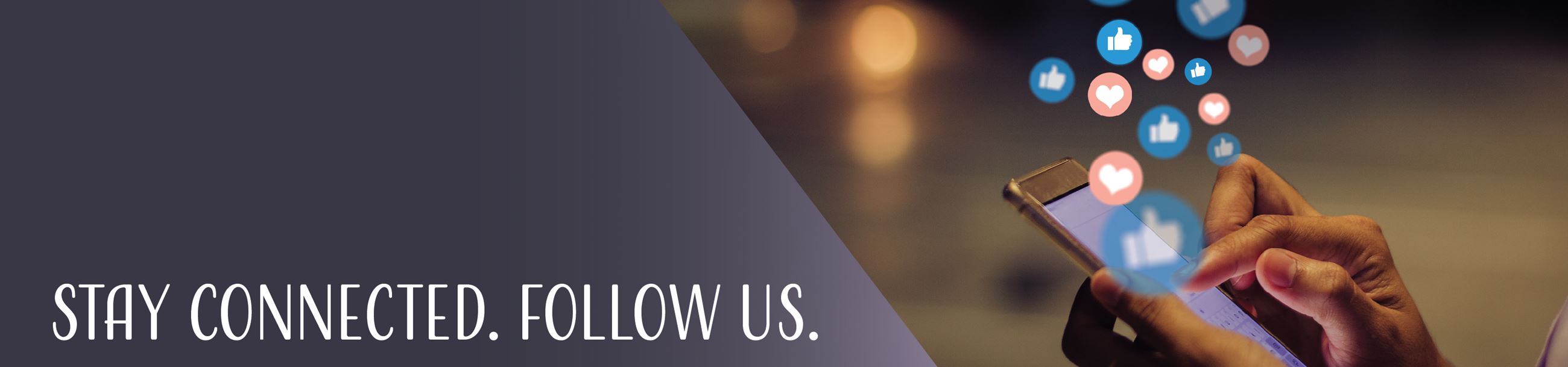 Stay Connected. Follow Us. Night time scene of hands using social media on a smart phone.